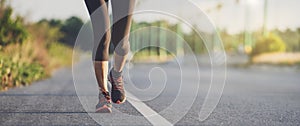 Runner feet running on road closeup on shoe. Woman fitness sunrise jog workout wellness concept. Young fitness woman runner athlet