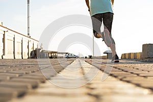 Runner feet running on road closeup on shoe. woman fitness sunrise jog workout welness concept.