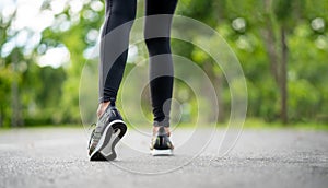 Runner feet running on road closeup on shoe. Young fitness woman runner athlete running at road. Athlete runner feet running on ro
