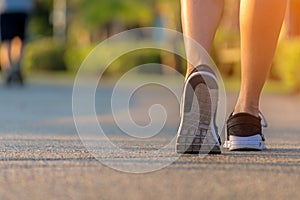 Runner feet running on the road in the outdoor workout park, closeup on shoe. Asian fitness woman running for healthy and relax