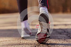 Runner feet with sport shoes on road