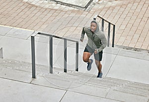 Runner, fitness and city stairs with a sports black man in the city for a cardio or endurance workout. Training