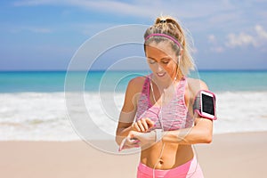 Runner girl checking activity data on wearable tech