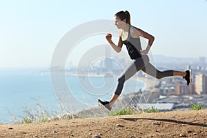 Runner girl running fast in city outskirts a sunny day