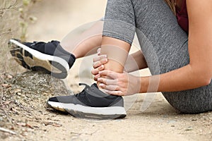 Runner grabbing sprained ankle in the mountain