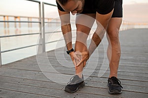 Runner guy having leg injury outside pressing shin in pain