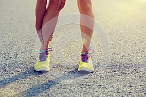 Runner holding her injured leg on road