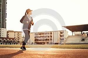 Runner jogging in sun light. Female fitness model training in the city. Healthy and lifestyle concept