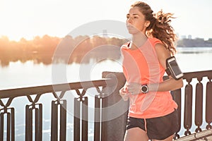 Runner is jogging in sunny bright light on sunrise.