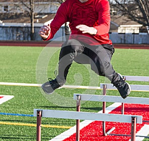 Runner jumping over hurdles for strngth and agility practice
