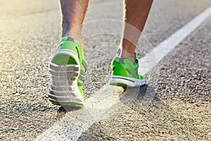 Runner man feet running on road closeup on shoe.