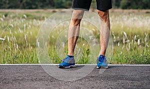 Runner man feet running on road closeup on shoe. Sports healthy lifestyle concept