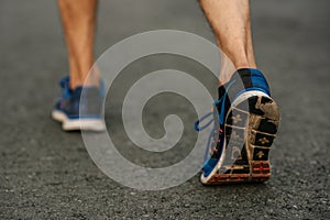 Runner man feet running on road closeup on shoe. Sports healthy lifestyle concept