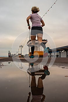 A runner passing a puddle while running at the beach