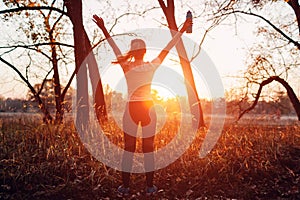 Runner raised arms after workout feeling free and happy succeeded in training. Woman admiring sunset