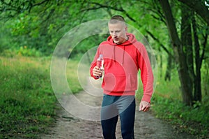 Runner in a red jacket with a hood and black sport leggins hold