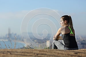 Runner resting contemplating view in city ouskirts