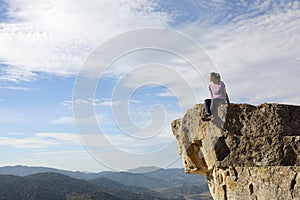 Runner resting contemplating views from the top of a cliff