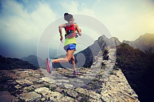 Runner running at great wall on the top of mountain