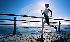 runner running on seaside boardwalk during sunrise