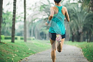 Runner running on tropical park trail