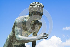 Runner sculpture in Achilleion, Corfu, Greece against the cloudy sky