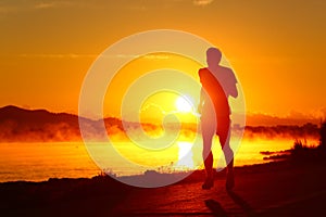 Runner silhouette running at sunset on the beach