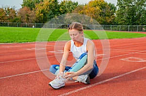 Runner sport leg injury. Woman has pain in ankle after workout outdoors at stadium