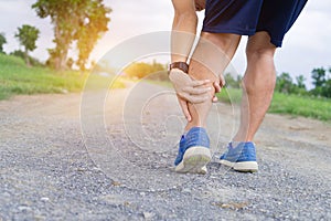 Runner sportsman holding leg in pain after suffering muscle injury during running workout training