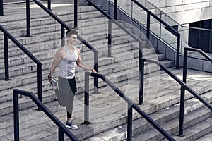 runner in sportswear warming up. Training on fresh air. Athletic young man stretching his legs muscles. sporty man