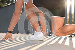 Runner on starting position outdoors on sunny day, closeup