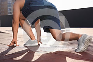 Runner on starting position outdoors on sunny day, closeup