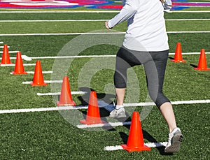 Runner steping over orange cones for speed training