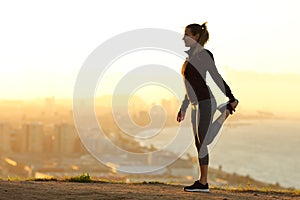 Runner stretching leg in city outskirts