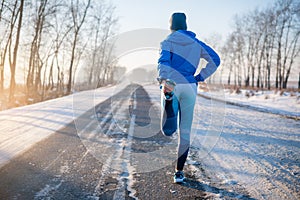 Runner stretching in winter Park. A healthy way of life.