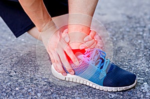 Runner touching painful twisted or broken ankle. Athlete runner training accident. Sport running ankle sprain