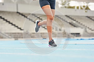 Runner, track and woman athlete on legs, fitness and outdoor exercise for sports competition. Race, stadium position and