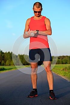 Runner training and checking stopwatch smart watch, cross country