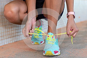 Runner tying her shoes before going for a run