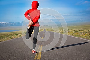 Runner warming up on country road