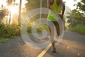 Runner warming up before running at morning forest trail