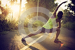 Runner warming up before running at morning forest trail