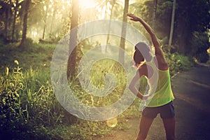 Runner warming up before running at morning forest trail