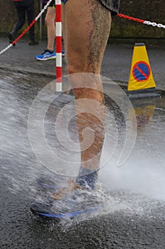 Runner washing mud from legs