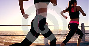 Runner, wellness or woman friends running at sunset on beach, ocean or sea pavement for training, health or exercise