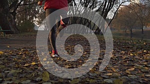 Runner woman feet running on autumn road closeup on shoe. Female fitness model outdoors fall jog workout on a road