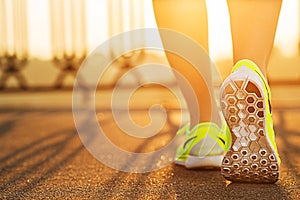Runner woman feet running on road closeup on shoe. Female fitness model sunrise jog workout. Sports lifestyle concept. photo