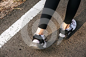 Runner woman feet running on road closeup on shoe. Sports healthy lifestyle concept