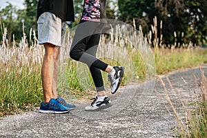 Runner woman and man feet running on road closeup on shoe. Sports healthy lifestyle concept