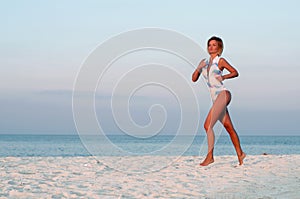 Runner woman running in the beach at sunset.